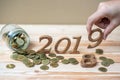 businessman putting Ã¢â¬Å2019Ã¢â¬Â wooden number with gold coins stack on wooden table Royalty Free Stock Photo